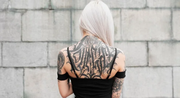Medium shot woman with tattoos on back-john mayer's tattoo ideas