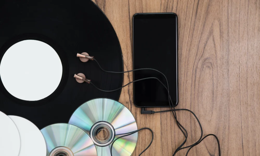 Close-up of an iPhone and CDs