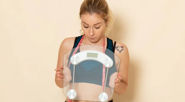 female in sport outfit holding scales-How Much Weight You Can Lose in 3 Months