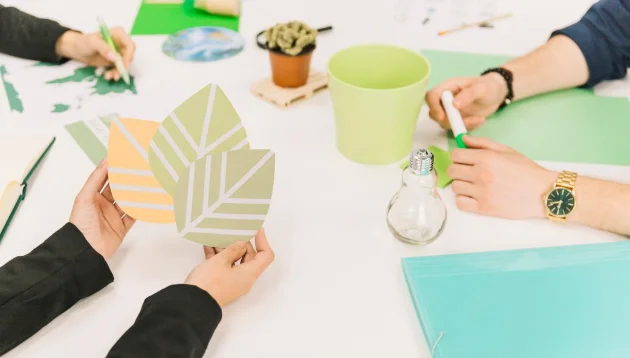 Hands crafting paper leaves with eco-friendly materials-lifestyle and trends