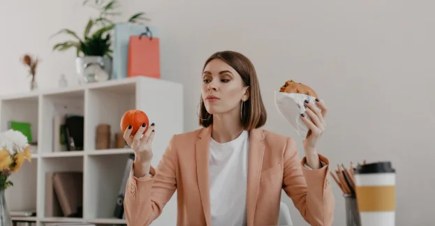  lady looks at apple reluctantly, wanting to eat burger-how long does it take to lose 30 pounds