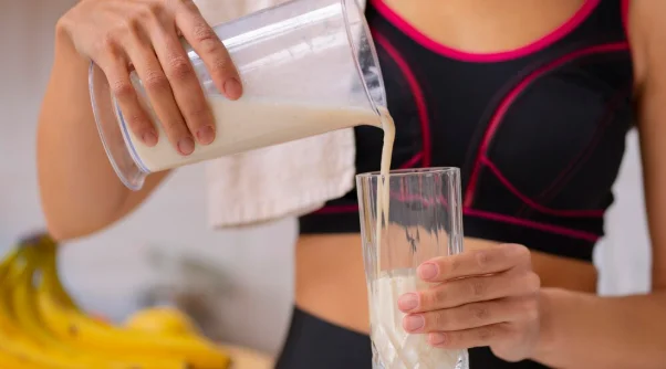 Front view woman pouring milk-Protein shakes in pregnancy