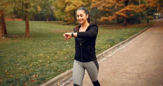Sports girl in a black top training in a autumn park