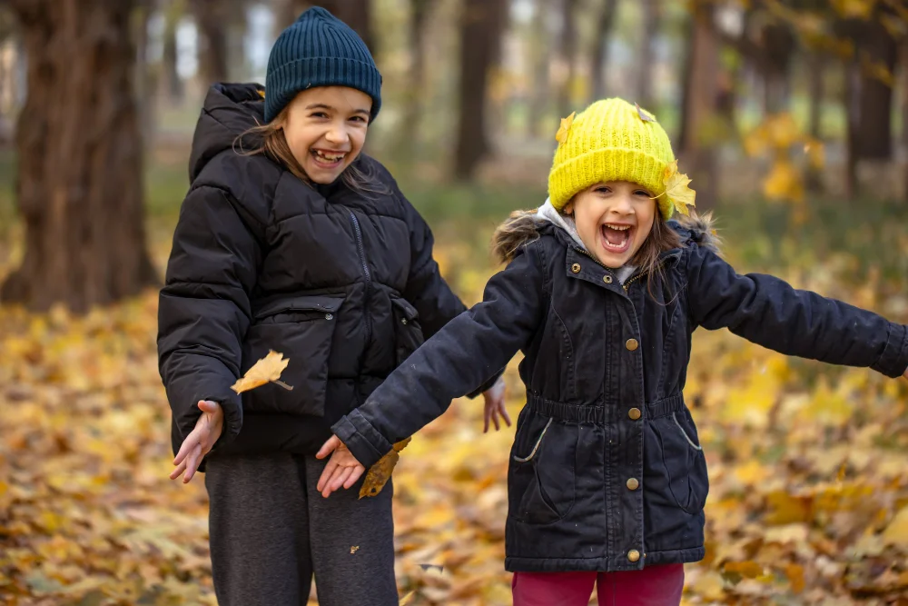 Children playing in the snow wearing jackets