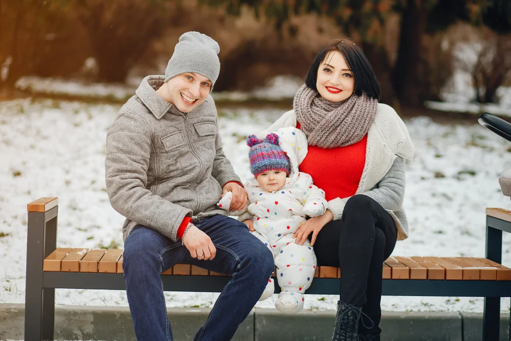 Family in casual winter outfits outdoors in snow
