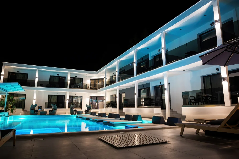 Modern luxury inn with pool and suites at night.