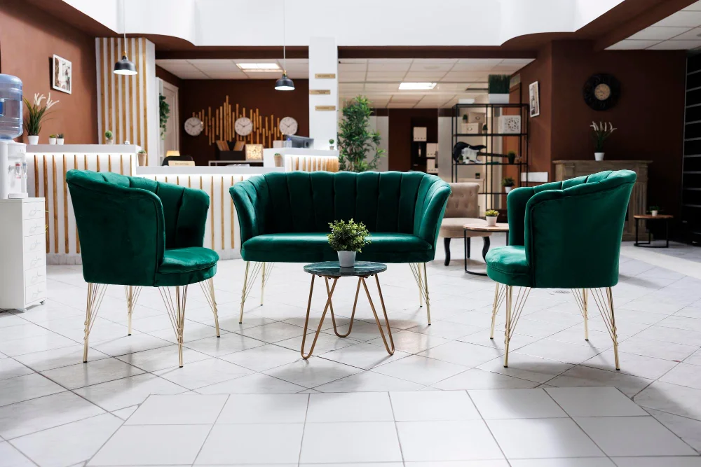 Stylish lobby area with emerald green velvet chairs and sofa around a small table