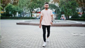 Stylish man in a casual jeans and T-shirt outfit walking in the city.